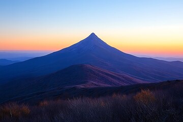 Naklejka premium Majestic mountain peak at sunset, casting shadows over rolling hills and valleys, serene atmosphere