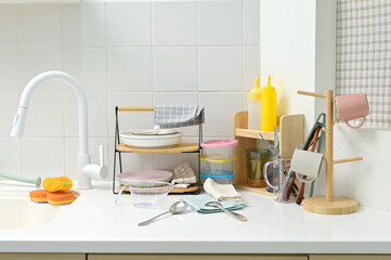 A kitchen sink in a typical home, with various kitchen utensils placed on it	