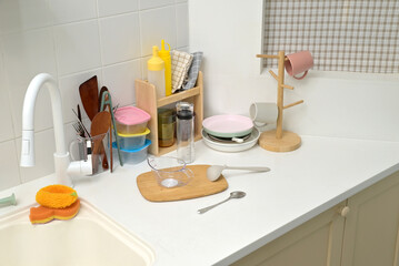 A kitchen sink in a typical home, with various kitchen utensils placed on it	
