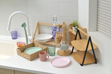 A kitchen sink in a typical home, with various kitchen utensils placed on it