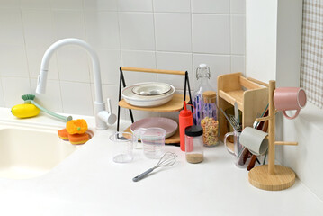A kitchen sink in a typical home, with various kitchen utensils placed on it