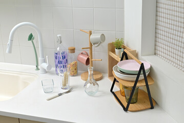 A kitchen sink in a typical home, with various kitchen utensils placed on it