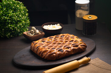 Curd pie on a fluffy ruddy dough on a dark wooden table