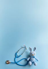 Blue Stethoscope with Cute Crochet Bunny – Pediatric Healthcare and Medical Care Concept, background 