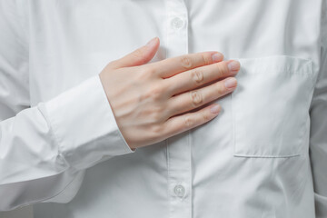 胸に手を当てる女性の手