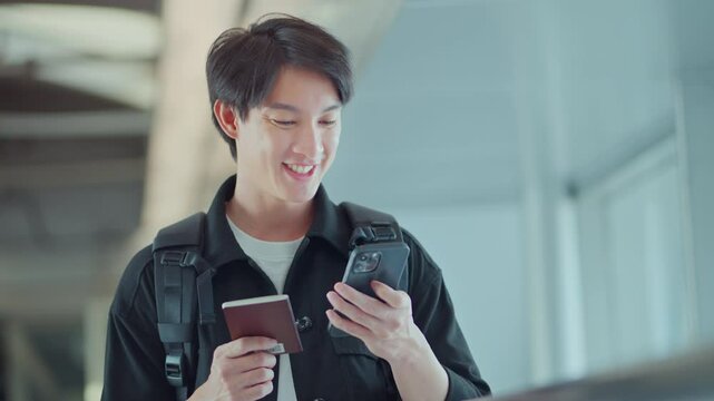 Happy traveling asian man uses mobile smartphone hold passport, checking trip destination on internet waiting at flight gates for plane boarding, Airport terminal, Tourist on vacation