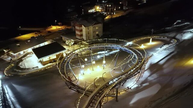 A thrilling aerial view of the bobsled track in Pec pod Sněžkou, Czech Republic. The winding track cuts through the beautiful mountain landscape, offering an exciting attraction for visitors.