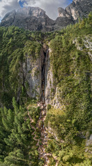 Fototapeta premium Detailed vertical drone panorama of the entire Cascate del Pisciadu waterfall in the Dolomites, Italy, captured on a sunny summer day with clear skies
