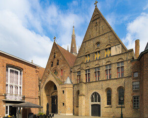 Fachada de iglesia medieval en Brujas, Bélgica, con arquitectura gótica de ladrillo y detalles ornamentales.