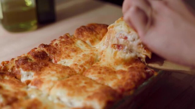 Serving homemade italian lasagna in a slow motion