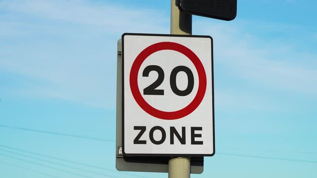 Speed limit sign of 20 zone in United Kingdom. Traffic regulation board with twenty restriction area in Britain. Road safety indicator displaying maximum velocity control in England