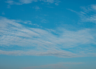 The background features a blue sky filled with beautiful white clouds.