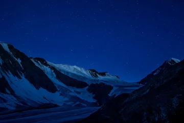 Selbstklebende Fototapeten Night photo of Aktru mountain and mountain range with glaciers and stars.  © rosimon