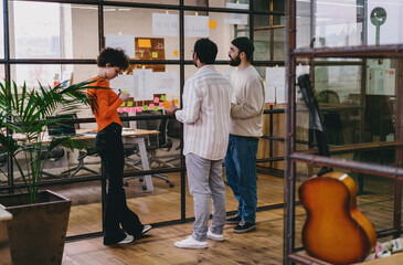 Group of colleagues discussing work strategy in modern office