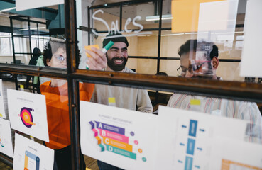 Cheerful colleagues analyzing diagrams in office