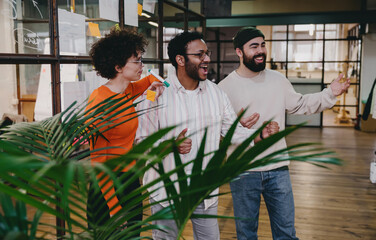 Cheerful diverse colleagues celebrating success in office