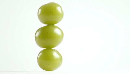 Three Green Grapes Stacked Vertically Against White Background