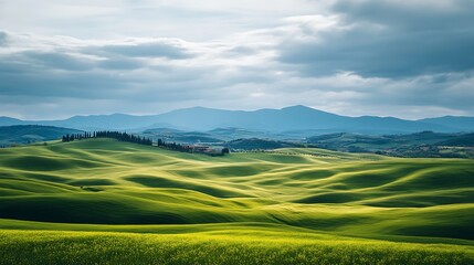 Obraz premium Rolling Green Hills Under a Cloudy Sky in Tuscany