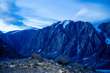 Night photo of Aktru mountain and mountain range with glaciers and stars.