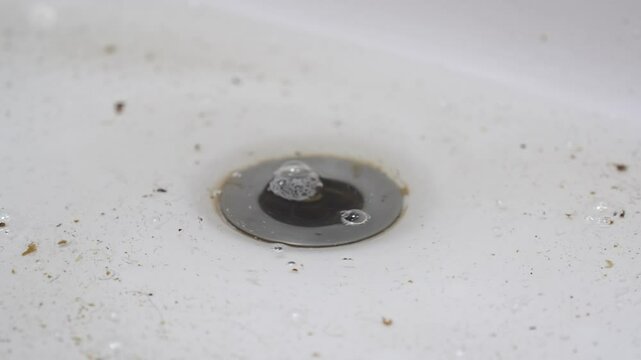 male hand cleans the sink from blockages. cleaning the drain from hair and debris in the bathroom.