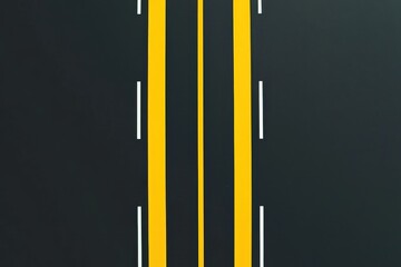 A straight road featuring double yellow lines and white lane markings, set against a dark asphalt background.