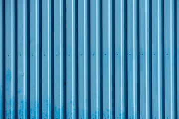 Blue corrugated metal wall forming a repetitive industrial pattern