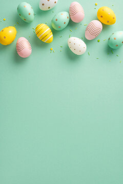 Naklejki Decorative vertical Easter eggs in pastel colors and different patterns arranged on a green surface