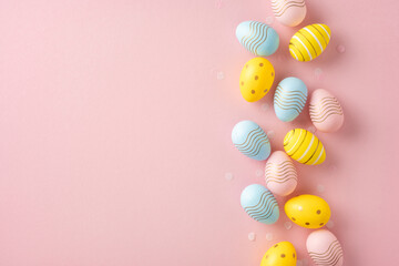 Delightful display of decorated pastel-colored Easter eggs aligned against a soft pink backdrop