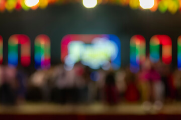 Blurred concert stage with colorful LED lights and audience