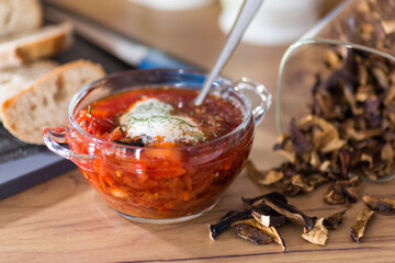 hot lean vegetable soup with beets and dried mushrooms on a wooden table