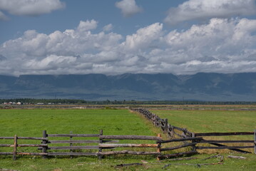 Russia. The Republic of Buryatia. View of fields in the valley of the Irkut river enclosed by wooden fences of a special zigzag structure made of logs.