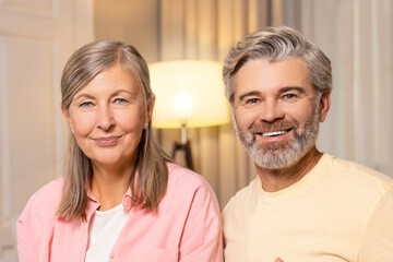 Mature couple spending time together at home and eating popcorn.