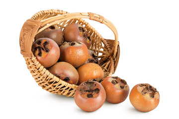 Brown fresh medlars in a wicker basket isolated on white background. Mespilus germanica close-up