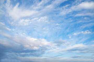 Blue sky adorned with soft wispy white clouds created a peaceful and uplifting atmosphere. A beautiful serene nature background. Nature, wellness, outdoor, mindfulness, environmental awareness.