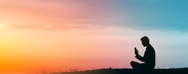 Silhouette of a man meditating during a vibrant sunset