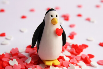Penguin with a heart on his chest surrounded by little hearts