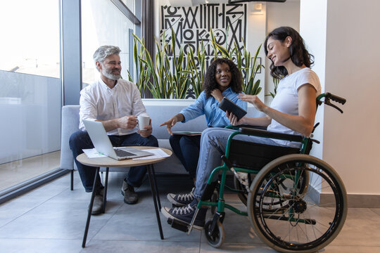 Diverse group of professionals including woman in wheelchair, brainstorming ideas for business