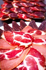 Sliced meat on a plate on a gray background