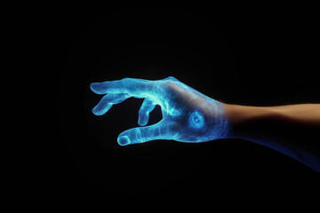 Obraz premium Hand of Technology: A person's hand is illuminated with blue light on black background, symbolizing digital interaction and technological innovation.