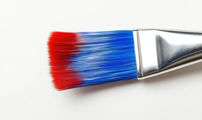 Fototapeta premium Close-up of a paintbrush with vibrant red and blue bristles against a white background