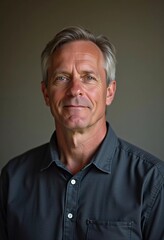 Obraz premium A mature man with gray hair, resident of USA, smiles gently. The warm lighting creates a cozy atmosphere. Calm, confident look. Experience, professionalism and intelligence in the eyes. Generative AI