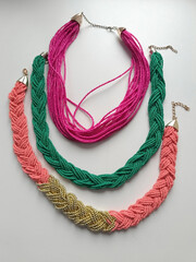 Three beaded harnesses in the hand-woven technique. Jewelry made of green, pink and red beads