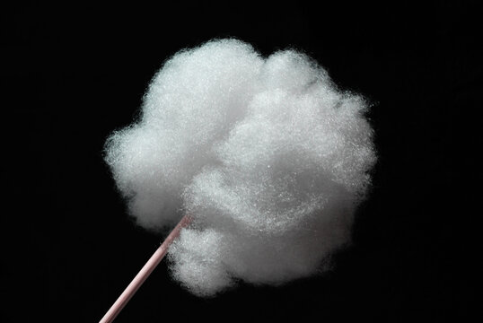 a lump of holofiber on a wooden stick on a black background