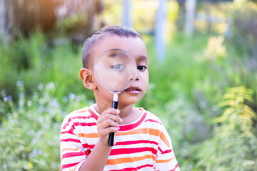 Kids exploring in forest with a magnifying glass