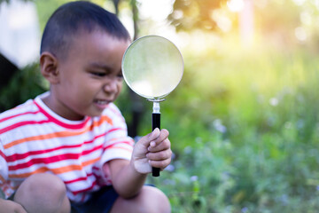 Kids exploring in forest with a magnifying glass