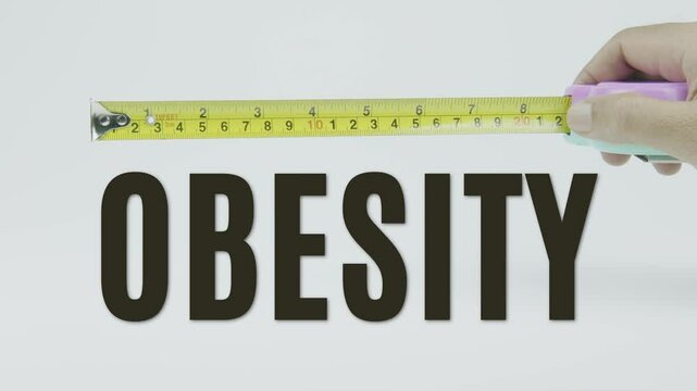 "Obesity" text with a tape measure on a white background, symbolizing precision, accuracy, and sizing in a clean, minimal style