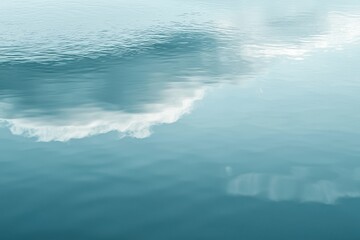 Fototapeta premium Serene blue water reflecting the sky with soft white clouds, creating a peaceful and calming atmosphere in a minimalist natural setting.