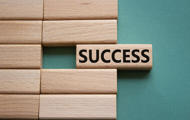 Success symbol. Concept word Success on wooden blocks. Beautiful grey green background. Business...