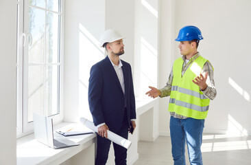 Contractor or builder collaborate with a businessman customer to plan a renovation or construction...