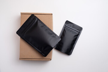 Black packages for tea, coffee, snacks and cosmetics in the background. Branding and packaging mockup for products. Packing closeup. Product for sale. Empty, mockup